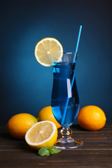 Glass of cocktail on table on dark blue background