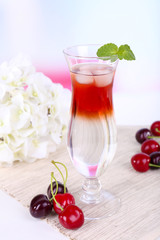 Glass of cocktail on table on light background