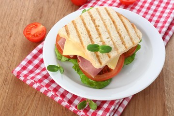 Tasty sandwich with ham on wooden table