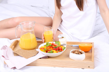 Obraz na płótnie Canvas Woman in bed with light breakfast