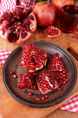 Ripe pomegranates with juice on table close-up