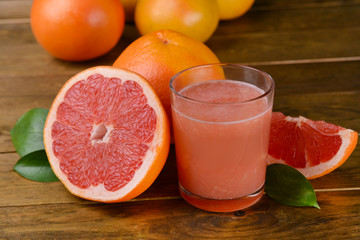 Ripe grapefruit with juice on table close-up