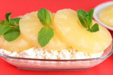 Bowl of tasty cottage cheese with pineapple, on red background
