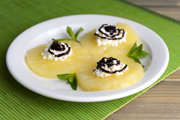 Tasty pineapple with cottage cheese on  wooden table