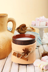 Mug of hot drink decorated in felt on wooden table