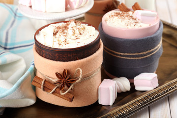 Mug of hot drink decorated in felt on wooden table