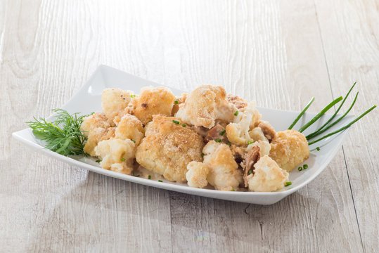 Cavolfiore gratinato con tonno servito su un piatto  bianco