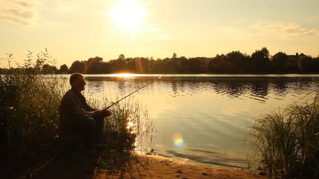 Man fishing. Fisherman. Sunset on the lake. summer landscape  