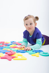 Little girl playing with letters and numbers