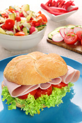 Sandwich with ham and tomatoes with vegetables salad