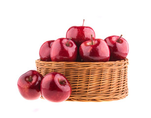 Fresh red apples in a wicker basket, isolated
