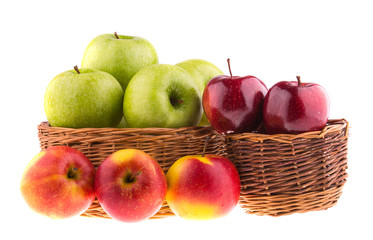 Fresh green and red apples in a wicker baskets, isolated