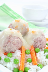 Pork meatballs with rice, carrots, peas and white sauce