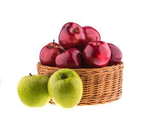 Green and red apples in a wicker baskets, isolated