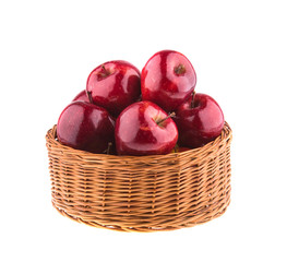 Red apples in a wicker basket, isolated