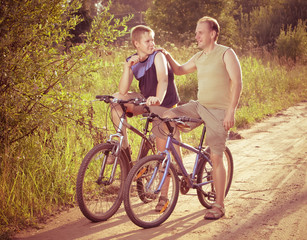 Fototapeta na wymiar The father with the son on bicycles,with a retro effect