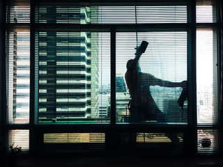 silhouette of a man cleaning building glass