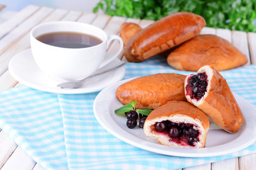 Fresh baked pasties with currant on plate on table close-up