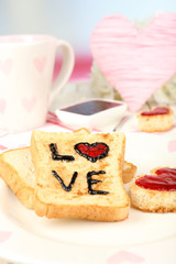 Delicious toast with jam and cup of tea on table close-up