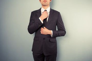 Young businessman adjusting his tie