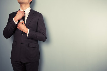Young businessman adjusting his tie