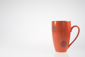 tazza arancio/rosso su sfondo bianco