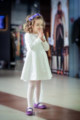 Naklejka premium Little cute girl looking at shop window in the mall.