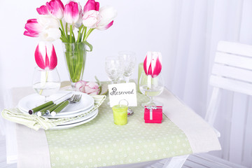 New table and chairs with place settings on light background