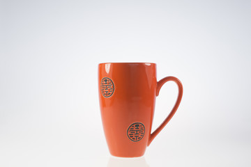 tazza arancio/rosso su sfondo bianco
