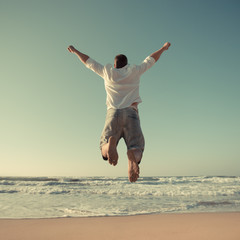 Funny man jumping at the beach