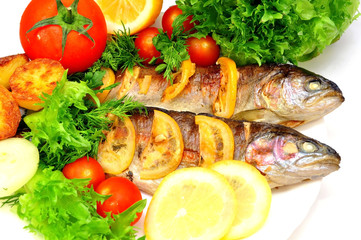 Fototapeta na wymiar grilled trout with fresh herbs, vegetables and lemon