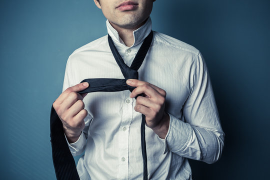 Young man tying his tie