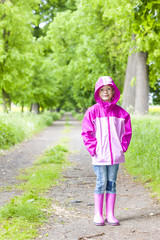 little girl wearing rubber boots in spring alley