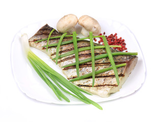 Grilled carp fillet on plate with onion.