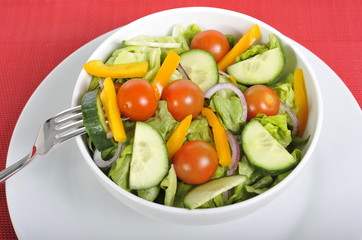 fork with cherry tomato, carrot in healthy salad bowl