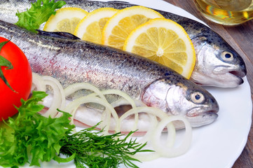 two rainbow trout with lemon and fresh vegetables