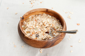 Muesli with raisin and fruits in wooden bowl
