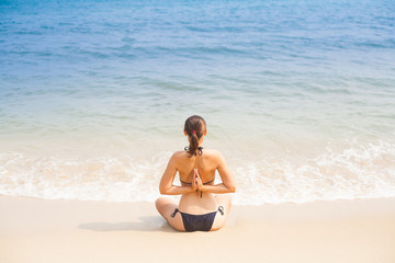 Fototapeta na wymiar Caucasian woman practicing yoga on beach
