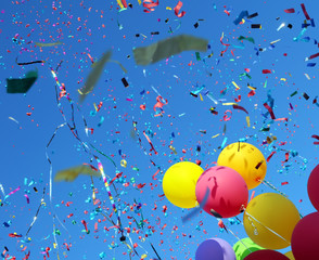 multicolored balloons and confetti on blue sky