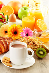 Breakfast with coffee, juice, croissant, salad, muesli and egg