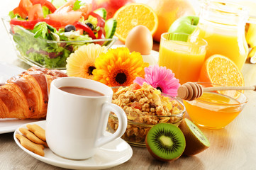 Breakfast with coffee, juice, croissant, salad, muesli and egg