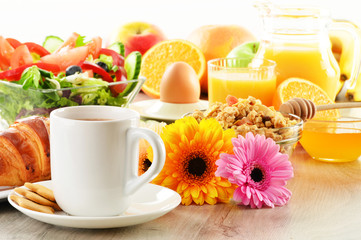 Breakfast with coffee, juice, croissant, salad, muesli and egg
