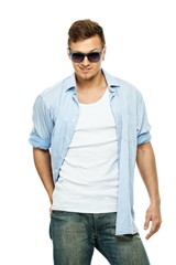 Fototapeta premium Stylish man in blue shirt and jeans wearing sunglasses isolated 