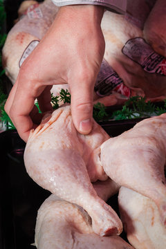 a man holding a chocken thigh