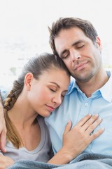 Fototapeta premium Peaceful couple relaxing on their sofa under blanket