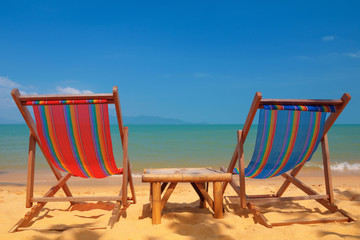 Two beach chairs on tropical shore