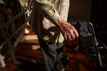 Elderly woman with walking frame in the staircase