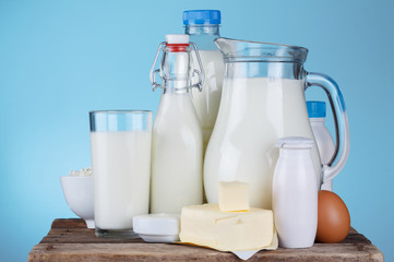 Dairy products assortment on old wooden table, blue background