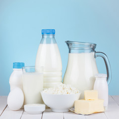 Dairy products assortment on wooden table, blue background