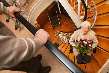 elderly couple in the staircase with stairlift
